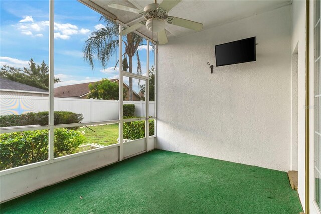 unfurnished sunroom with ceiling fan