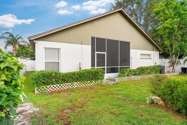 view of home's exterior with cooling unit, a yard, and a sunroom