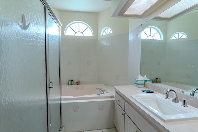 bathroom featuring plenty of natural light, vanity, a skylight, and independent shower and bath