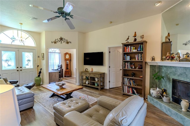 living room with a fireplace, a textured ceiling, hardwood / wood-style flooring, and ceiling fan