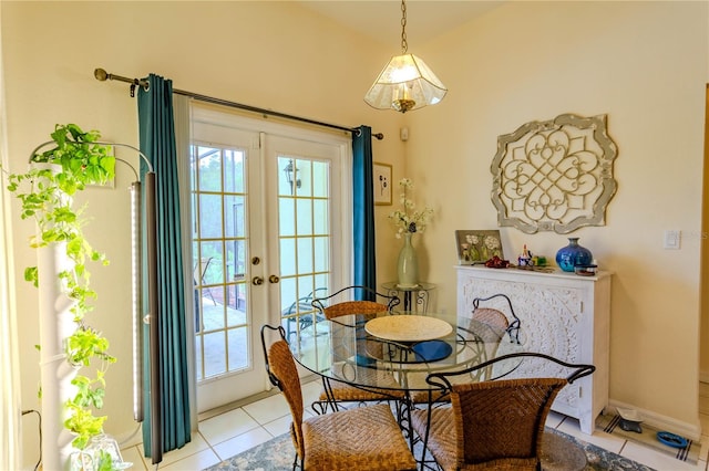 tiled dining space with lofted ceiling, a healthy amount of sunlight, and french doors