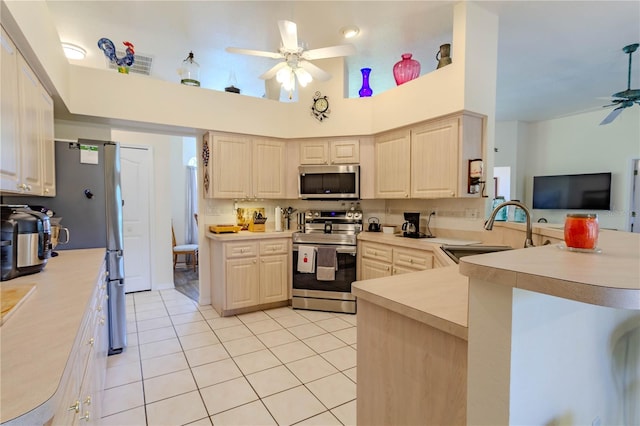 kitchen featuring ceiling fan, stainless steel appliances, kitchen peninsula, and sink