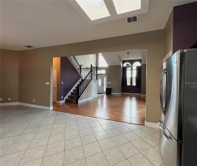 interior space featuring light wood-type flooring and stainless steel refrigerator