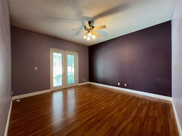 spare room featuring dark wood-type flooring, a textured ceiling, french doors, and ceiling fan