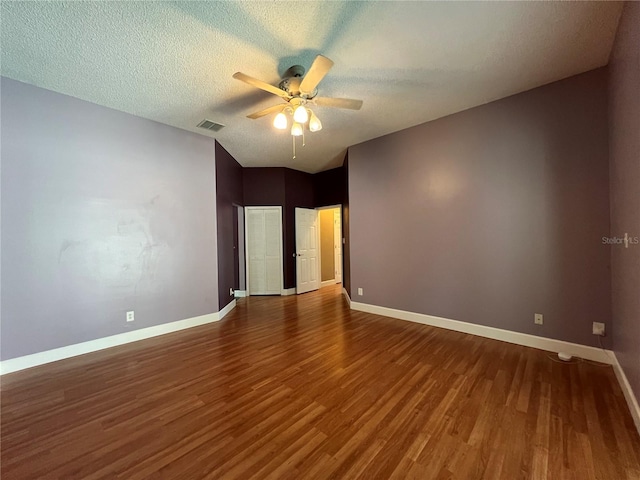 spare room featuring a textured ceiling, dark wood-type flooring, and ceiling fan