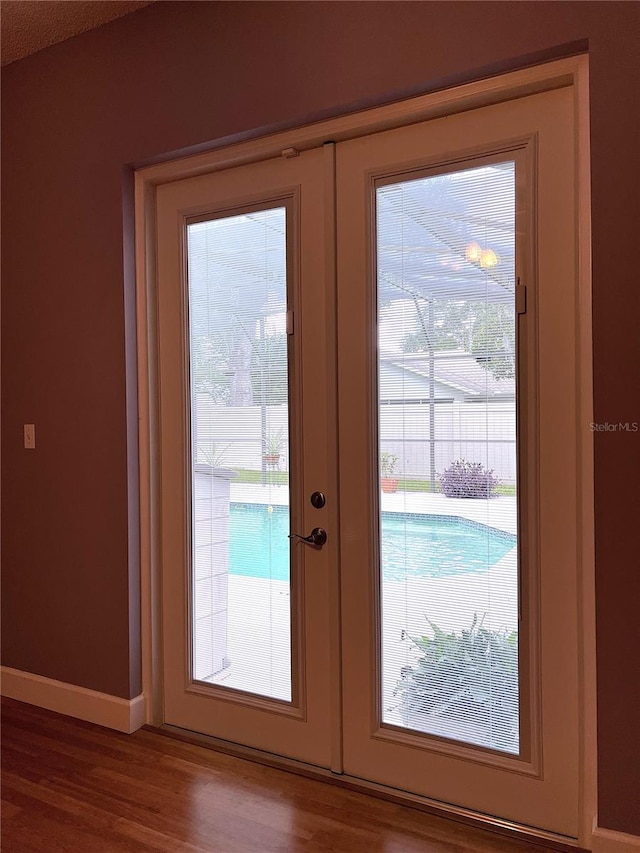 entryway with a wealth of natural light, hardwood / wood-style floors, and french doors