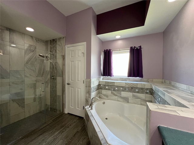 bathroom with hardwood / wood-style flooring and shower with separate bathtub