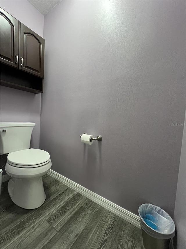 bathroom with toilet and wood-type flooring