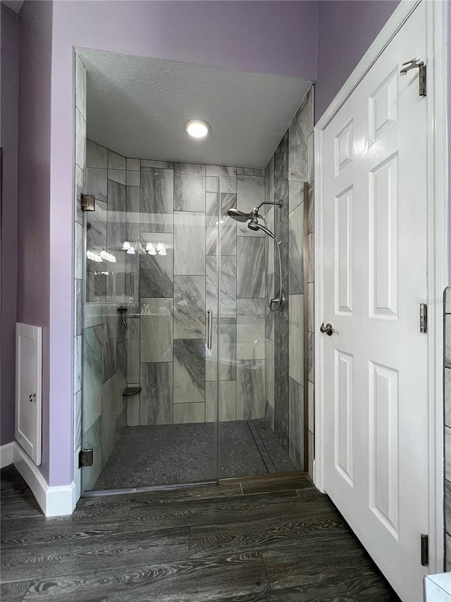 bathroom featuring walk in shower, a textured ceiling, and hardwood / wood-style floors