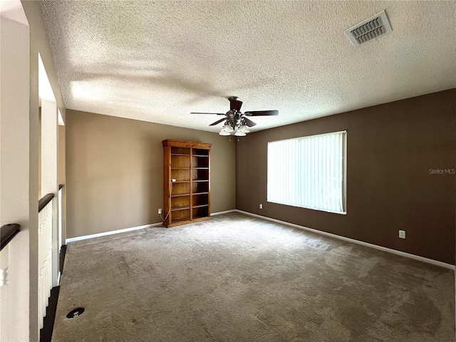 carpeted empty room featuring a textured ceiling and ceiling fan