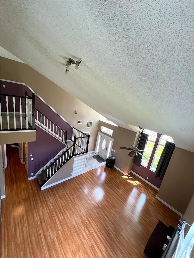 living room featuring a textured ceiling, hardwood / wood-style flooring, and ceiling fan