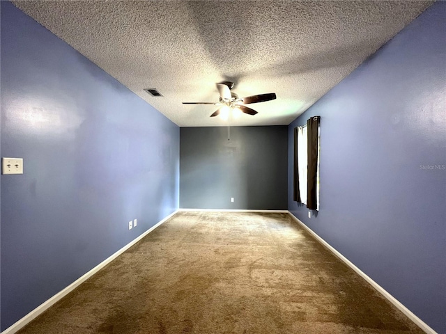 empty room with ceiling fan, carpet, and a textured ceiling