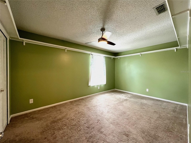 unfurnished room with a textured ceiling, ceiling fan, and carpet floors