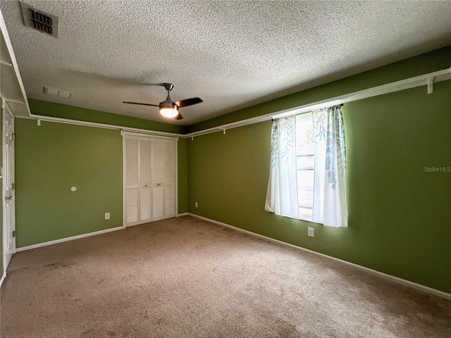 unfurnished bedroom featuring a textured ceiling, carpet, ceiling fan, and a closet