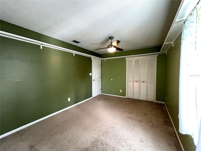 interior space with a closet, a textured ceiling, ceiling fan, and carpet floors