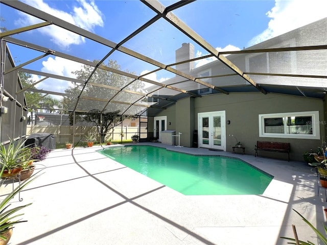 view of pool with french doors, a lanai, and a patio area