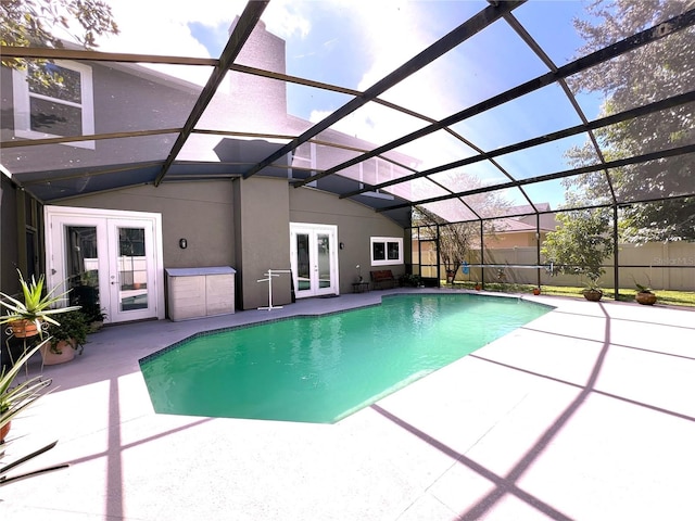 view of pool featuring glass enclosure, a patio, and french doors