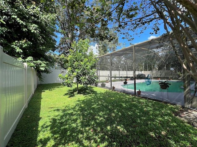 view of yard featuring a fenced in pool and glass enclosure