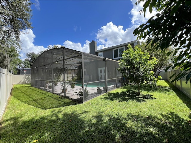 exterior space featuring glass enclosure, a yard, and a patio area