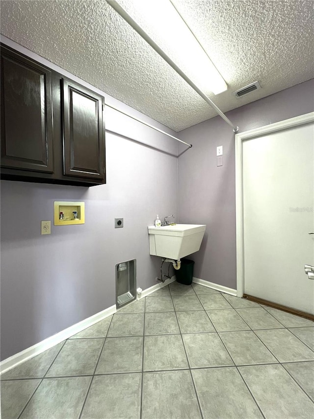 laundry room featuring cabinets, sink, electric dryer hookup, washer hookup, and light tile patterned flooring