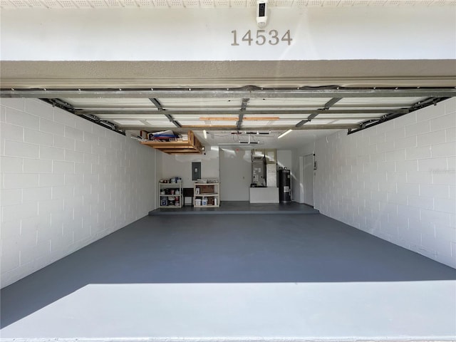 garage featuring electric panel and water heater