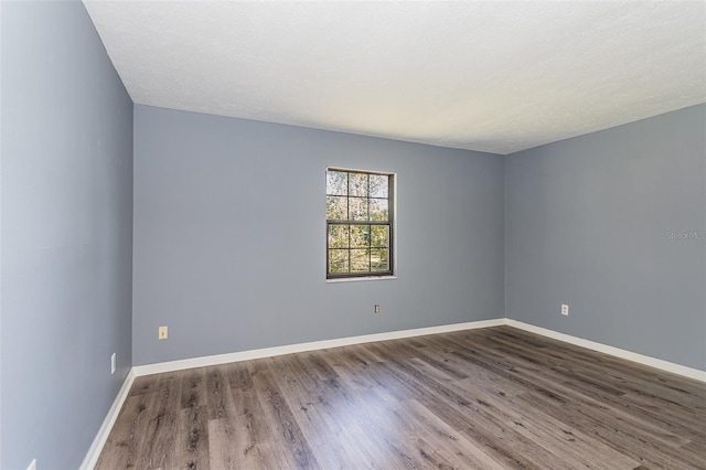 empty room featuring wood-type flooring and a textured ceiling