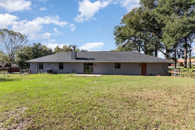 rear view of house with a lawn and cooling unit