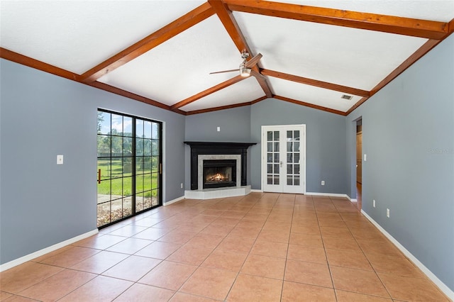 unfurnished living room featuring light tile patterned floors, lofted ceiling with beams, ceiling fan, and a tiled fireplace