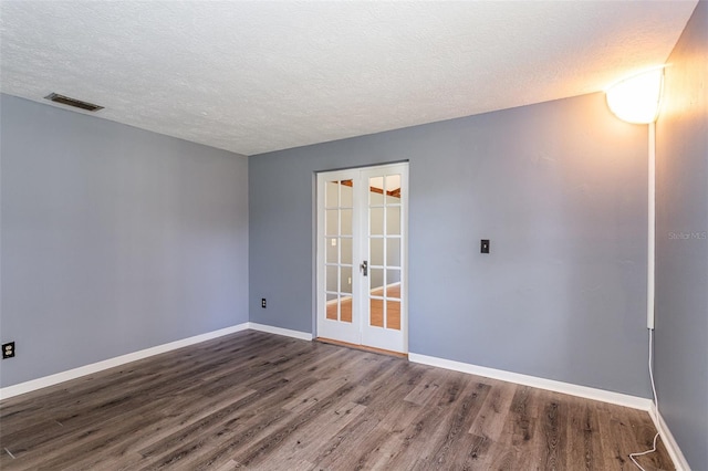 unfurnished room featuring a textured ceiling, french doors, and dark hardwood / wood-style floors