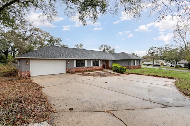 ranch-style house featuring a garage, brick siding, concrete driveway, and a front yard