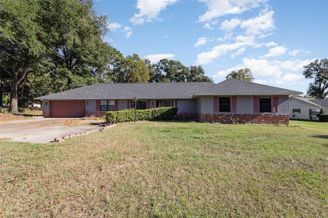 single story home with a garage, stucco siding, driveway, and a front lawn