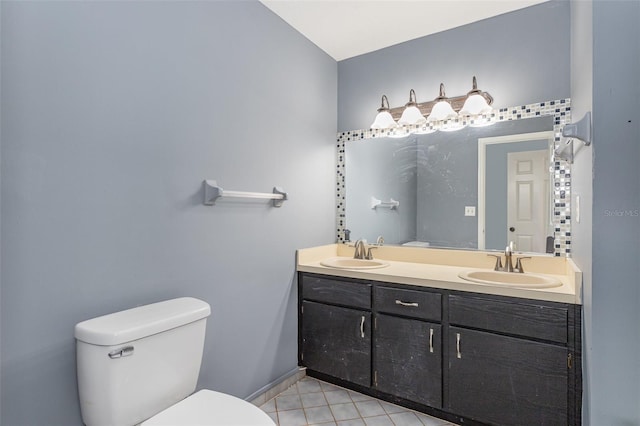 full bath with double vanity, tile patterned floors, toilet, and a sink