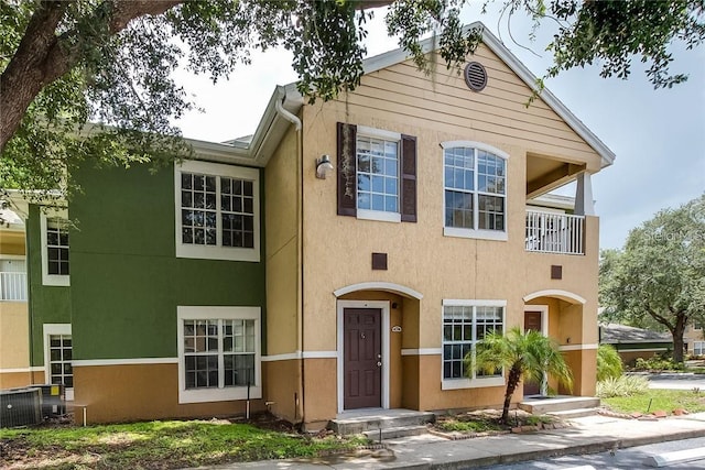 view of front of house featuring a balcony and central AC unit