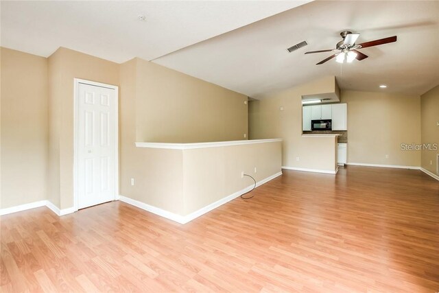 spare room featuring vaulted ceiling, ceiling fan, and light hardwood / wood-style floors