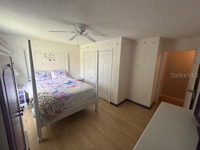 bedroom with a textured ceiling, a closet, ceiling fan, and hardwood / wood-style floors