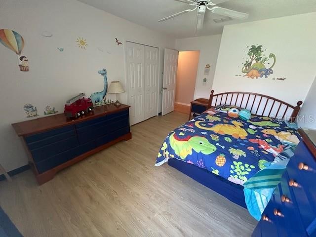 bedroom featuring wood-type flooring, ceiling fan, and a closet