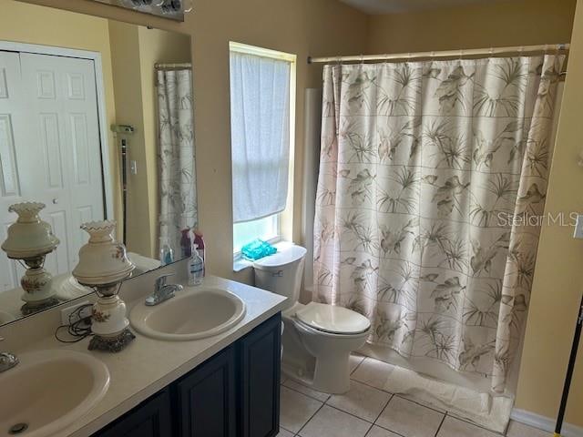 bathroom with vanity, toilet, plenty of natural light, and tile patterned flooring