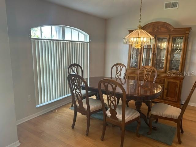 dining area featuring light wood-type flooring and a chandelier