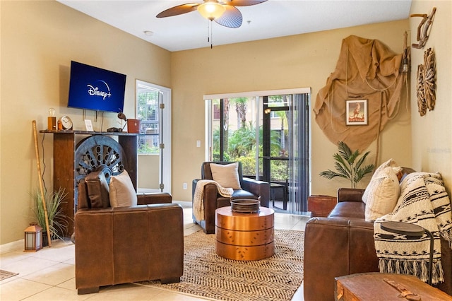 living room with light tile patterned flooring, baseboards, and ceiling fan