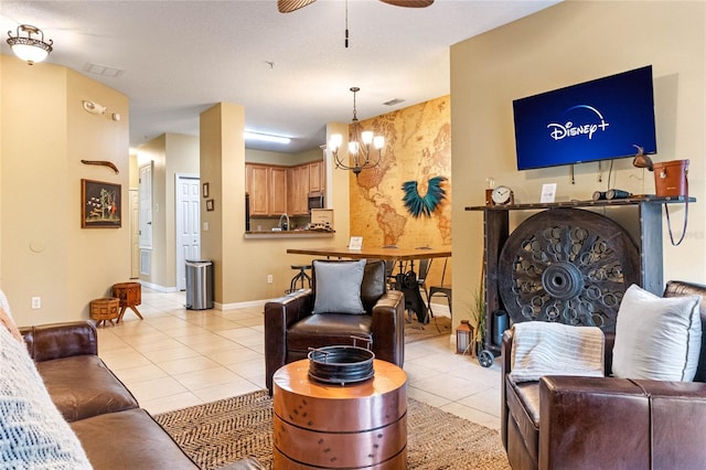 tiled living room featuring ceiling fan with notable chandelier and a fireplace