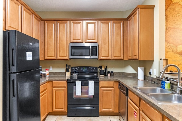 kitchen featuring black appliances, light tile patterned floors, a textured ceiling, and sink