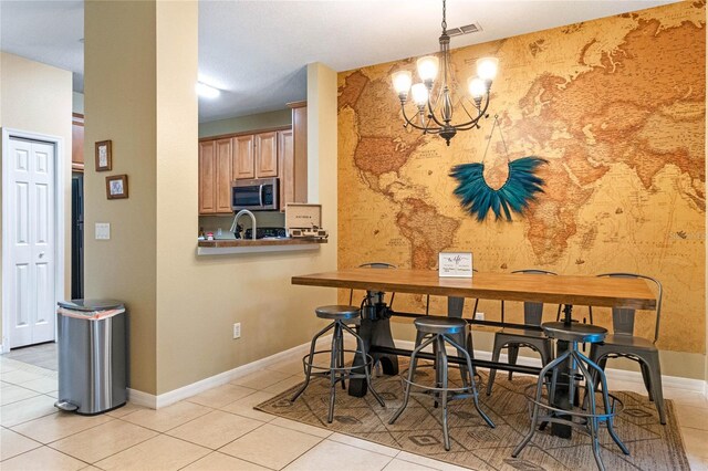 dining area featuring a notable chandelier and light tile patterned flooring