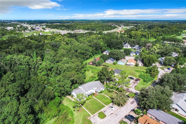 drone / aerial view with a wooded view and a residential view