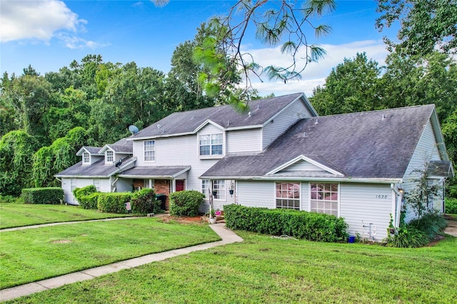 view of front of property with a shingled roof and a front lawn