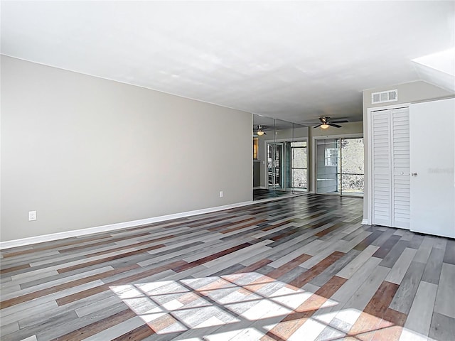 unfurnished living room featuring visible vents, wood finished floors, baseboards, and ceiling fan