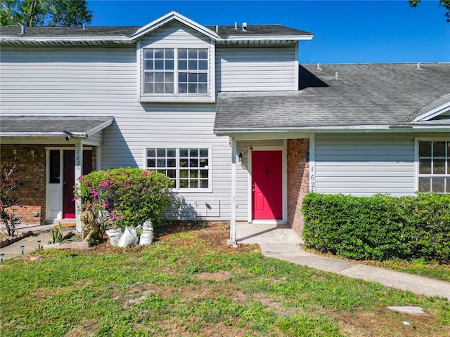 view of front of house with brick siding and a shingled roof