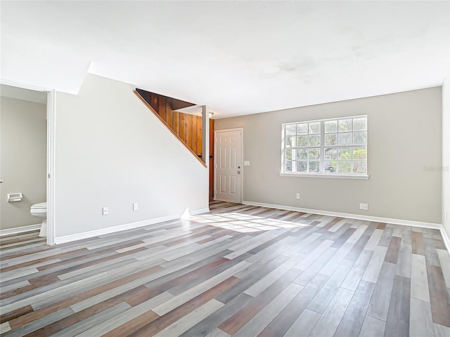 interior space with stairway, light wood-style flooring, and baseboards