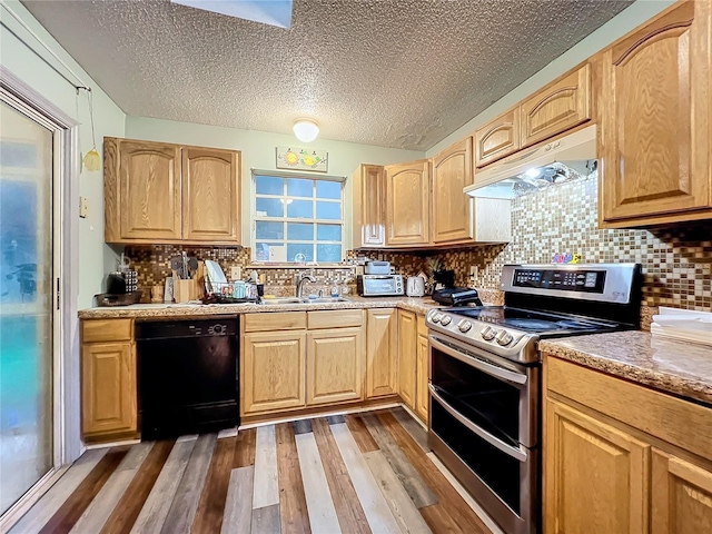 kitchen featuring wood finished floors, double oven range, a sink, under cabinet range hood, and dishwasher