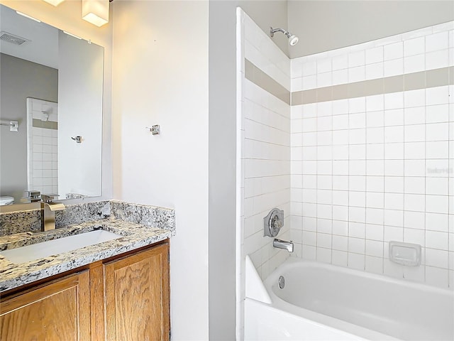 bathroom with visible vents, tub / shower combination, and vanity