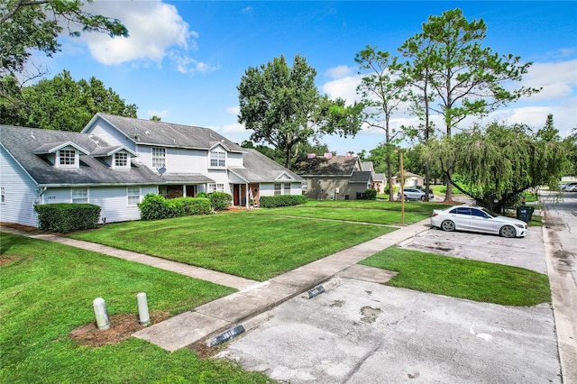 view of front of house featuring uncovered parking and a front lawn